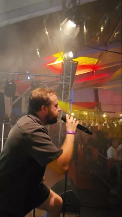 Sänger Dominik mit Mikrofon beim Backfischfest-Auftritt von District Lounge in Worms